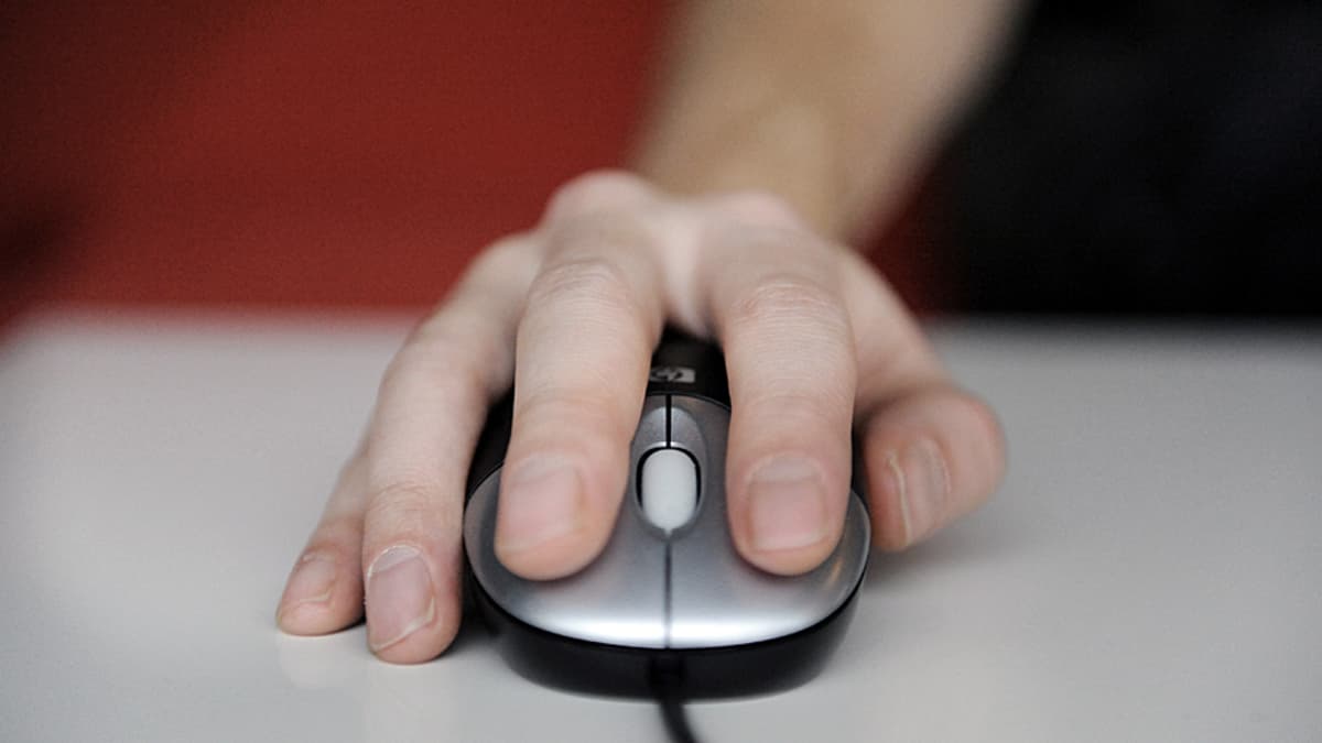 Käsi ohjaa tietokoneen hiirtä.