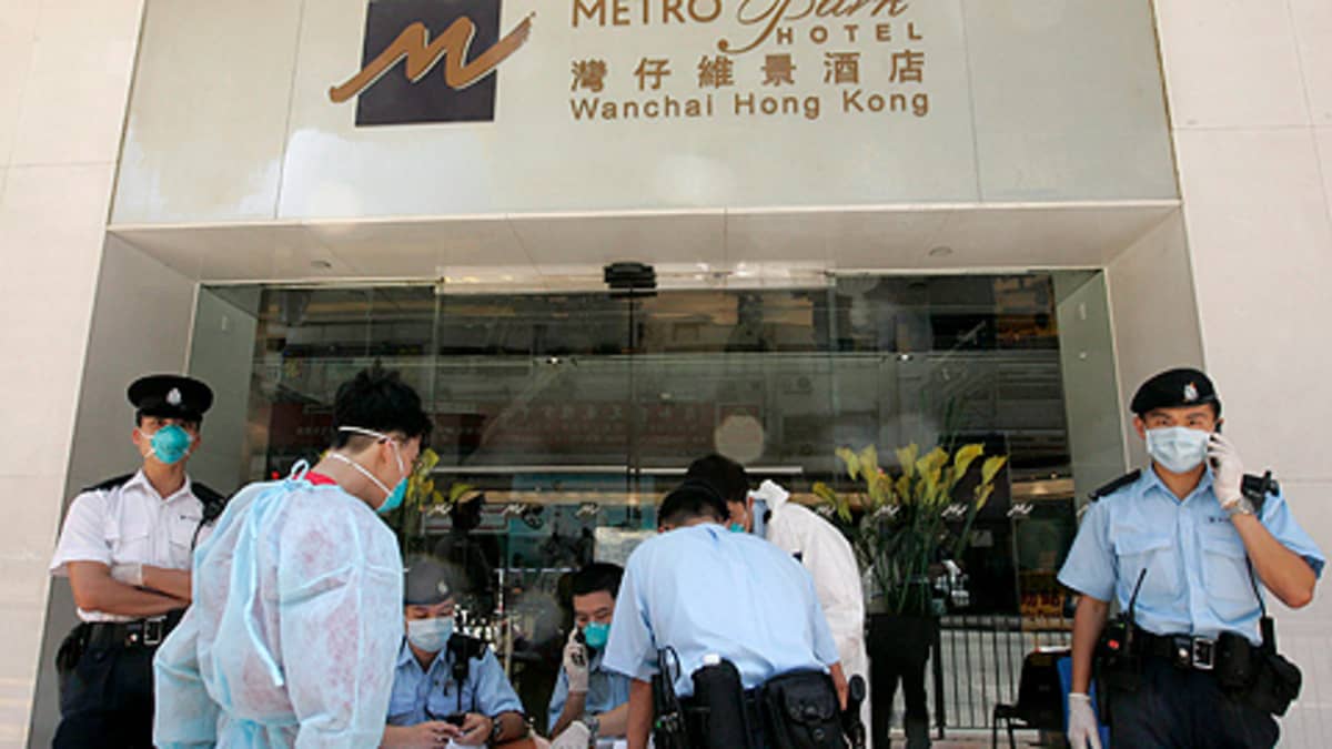 Poliiseja ja terveysviranomaisia karanteeniin julistetun Metropark-hotellin edustalla Hong Kongissa.