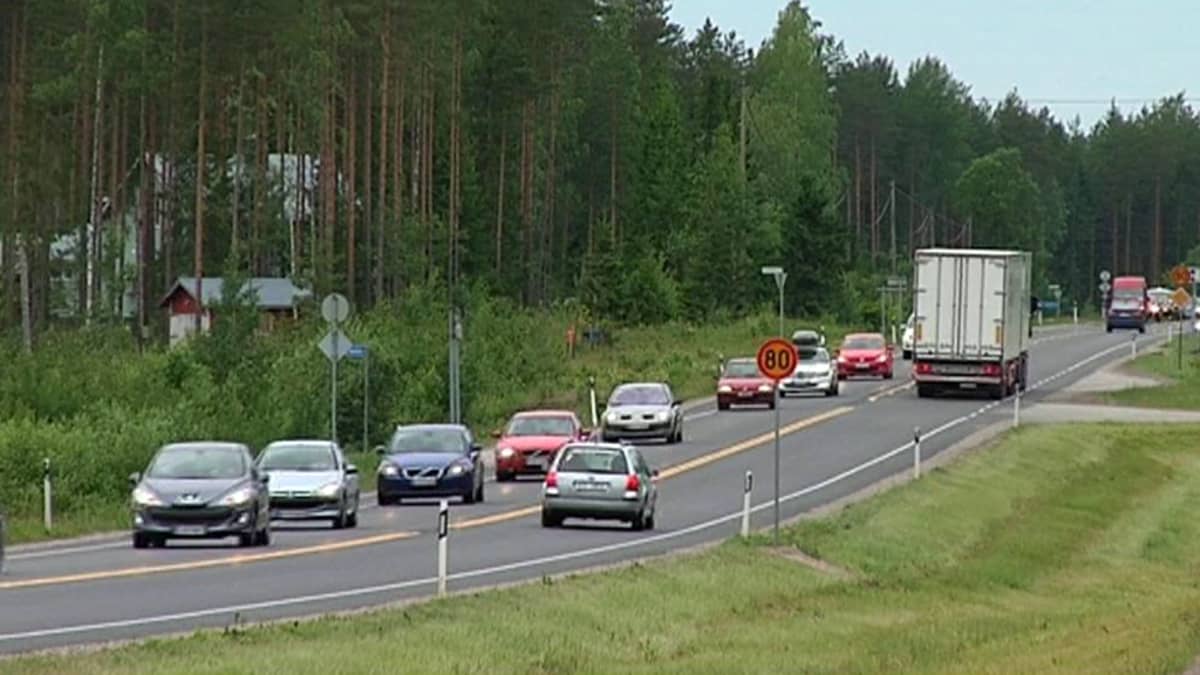 Kuorma- ja henkilöautoja maantiellä.