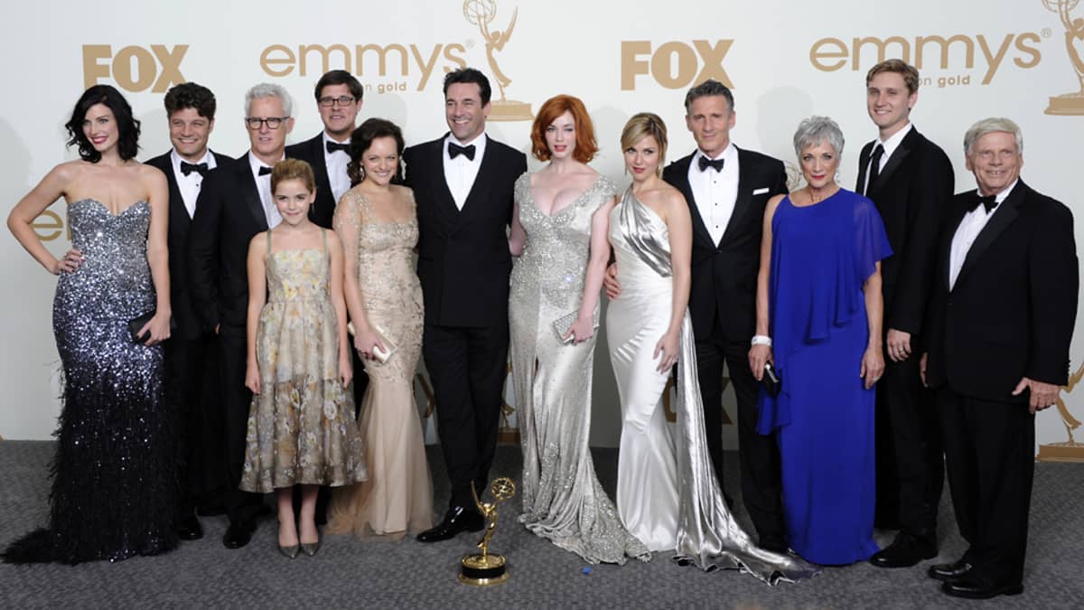 Mad Men -sarjan tuotantoryhmä poseeraa Emmy-pokaalin kanssa.