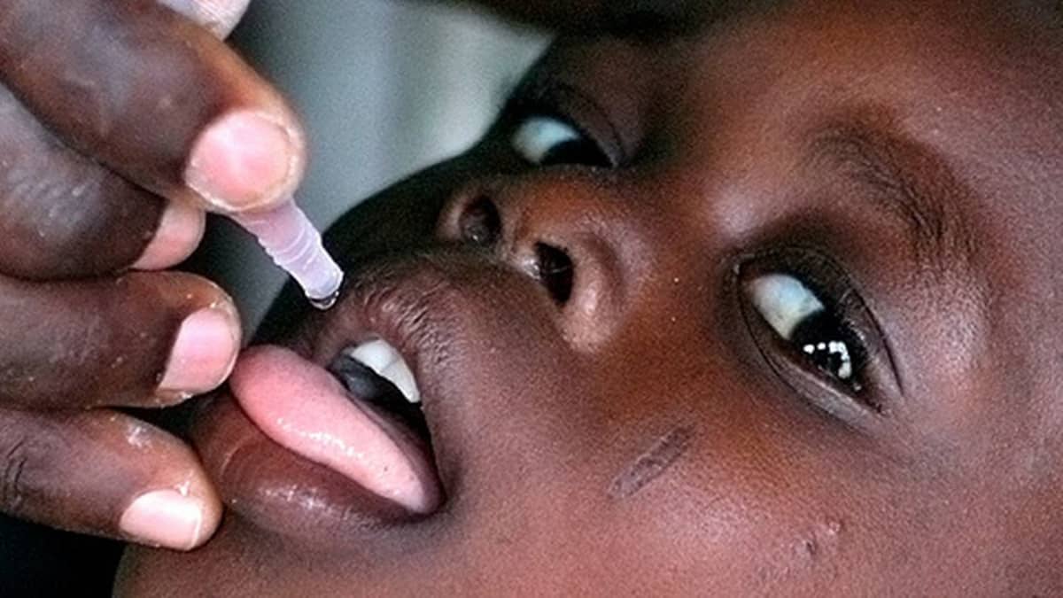Nigerialaislapsi saa poliorokotuksen Abubun kylässä lähellä pääkaupunki Lagosia.