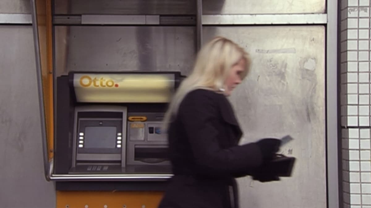 Nainen asioimassa pankkiautomaatilla