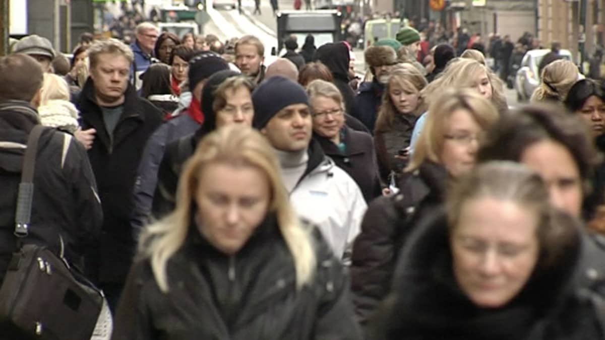 Ihmisiä kadulla talvivaatteissa.