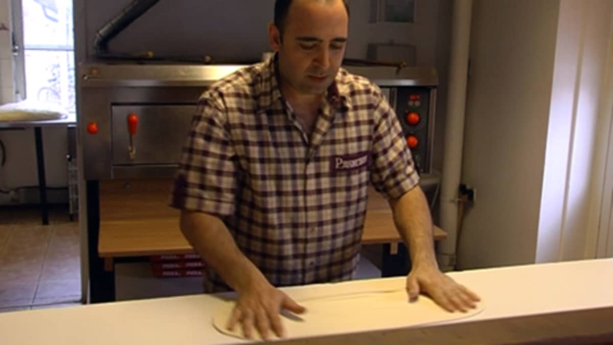 Ravintoloitsija Erkan Uzun pyöräyttää pizzapohjan.