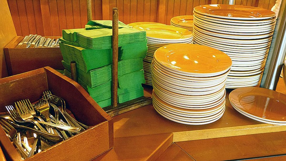 Kuvassa lounasravintolan noutopöytä ja aterimia, lautasia ja lautasliinoja