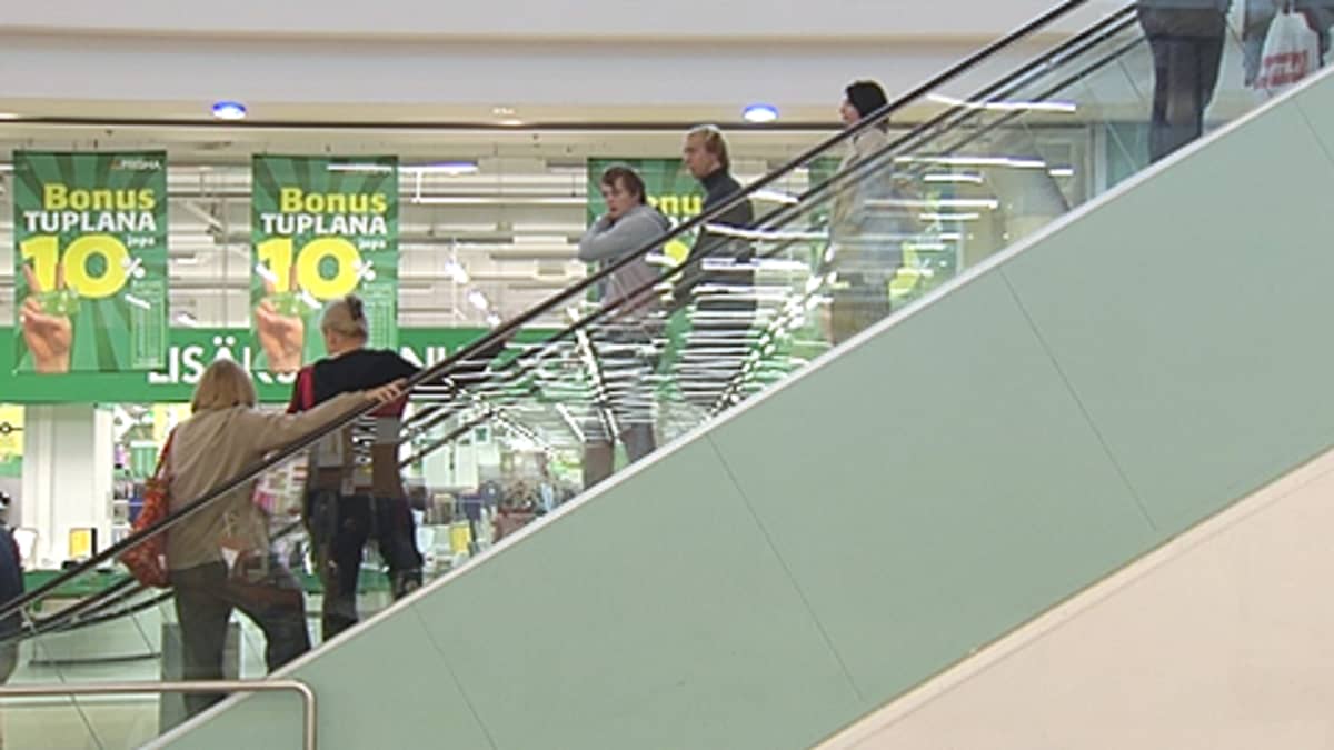Ihmisiä liukuportaissa Prisma-kauppakeskuksessa.