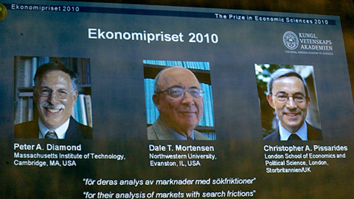 Talouden Nobel-palkinnon voittajien kuvat heijastettuna kankaalle palkinnon julkistamistilaisuudessa.