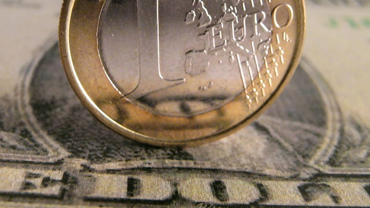 Euron kolikko yhden dollarin setelin päällä.
