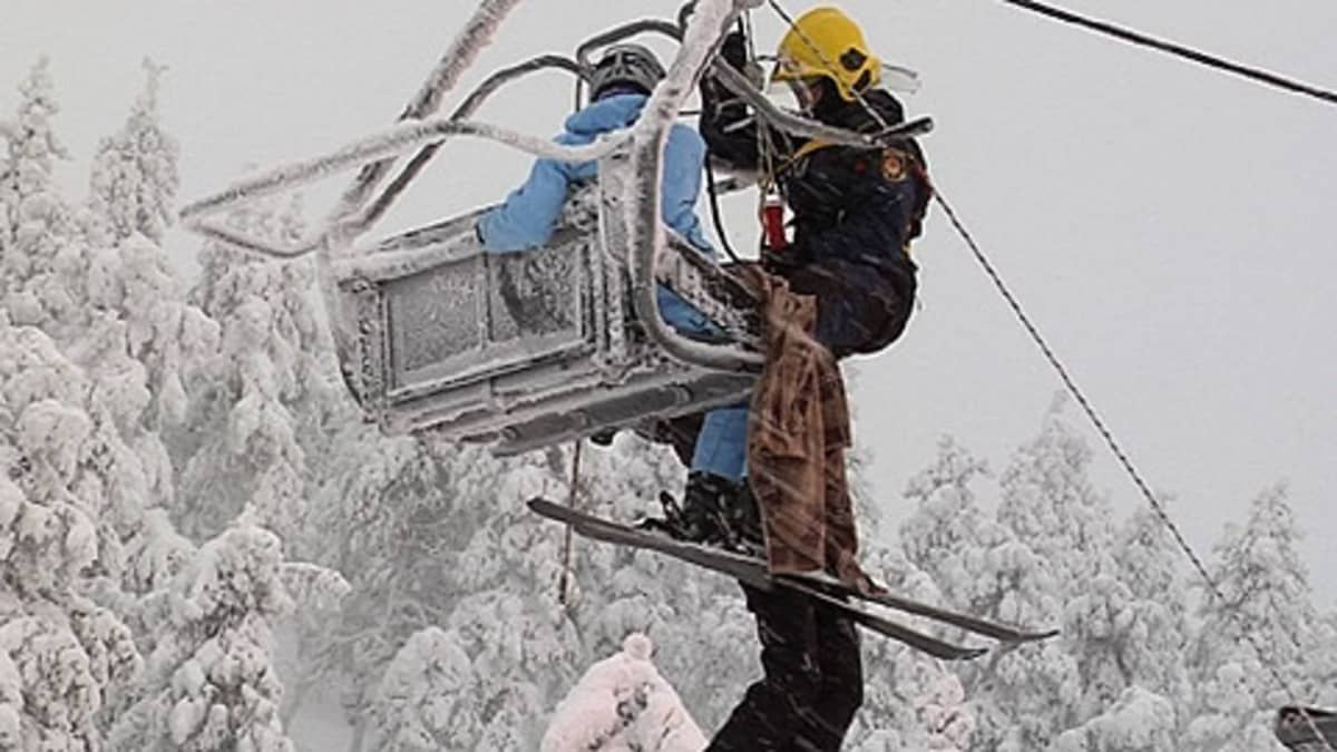 Pelastustyöntekijä auttamassa ihmisiä alas jumiutuneesta hiihtohissistä. Kuva on joulukuussa pidetystä harjoituksesta