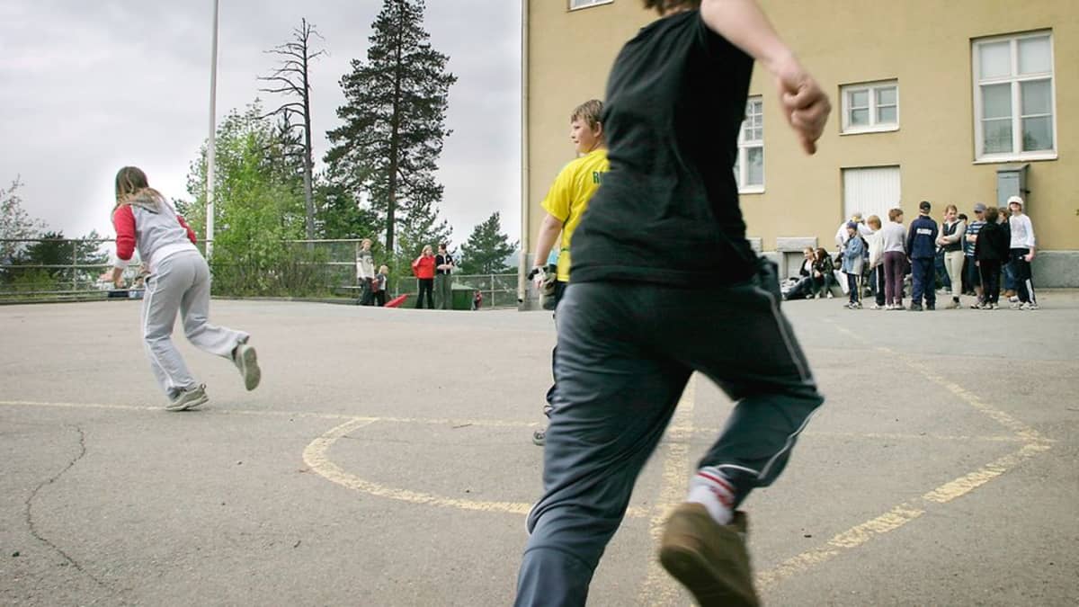 Pispan koulun oppilaita pelaamassa liikuntatunnilla koulun pihalla pesäpalloa.