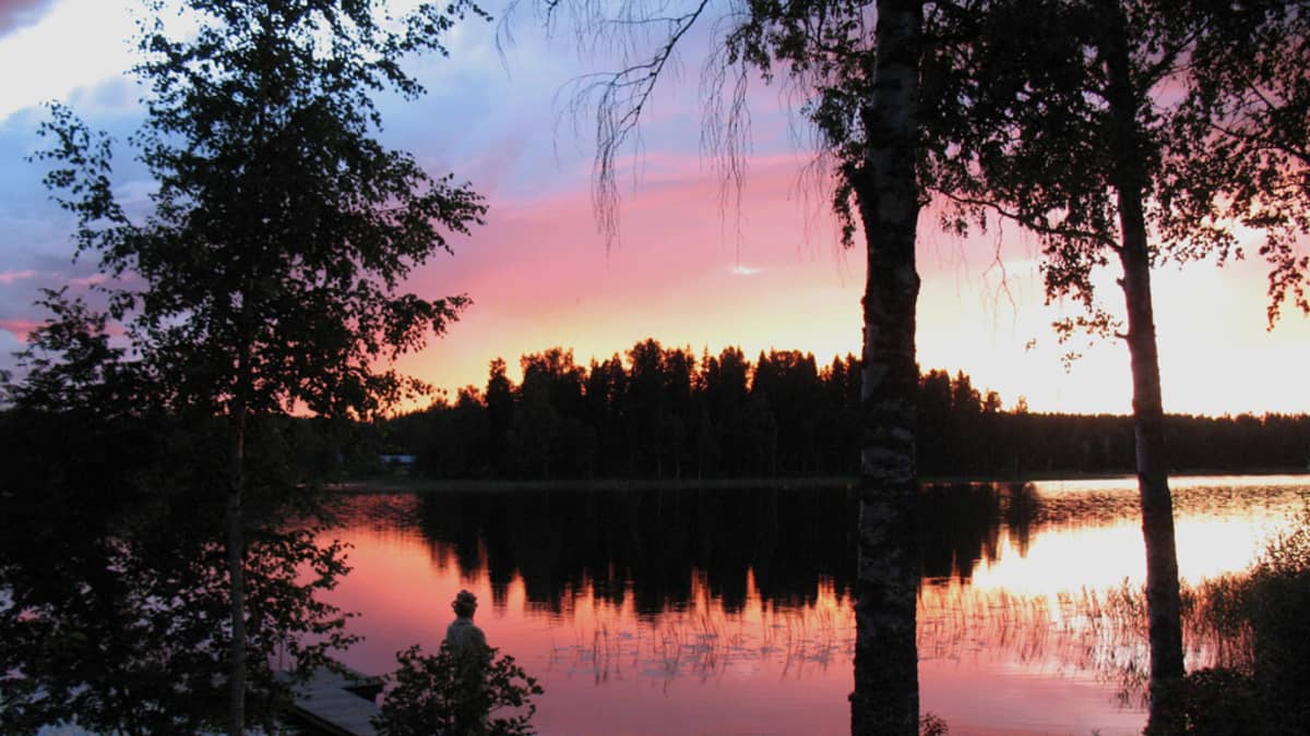 Auringonlasku järven rannalla.