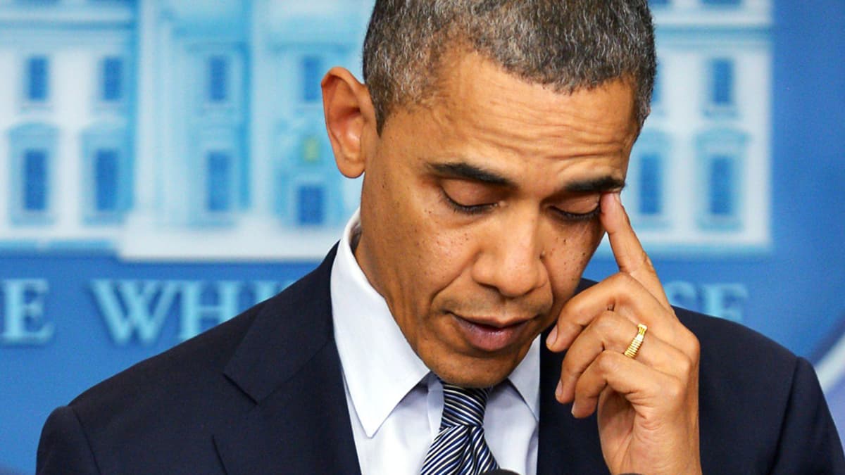 Barack Obama pyyhkii kyyneleitä puhujankorokkeella.