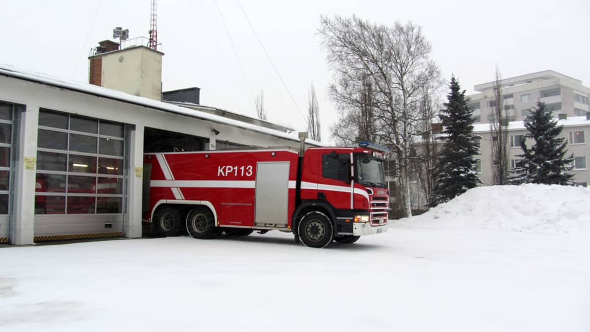 Paloauto lähdössä paloaseman ovesta.