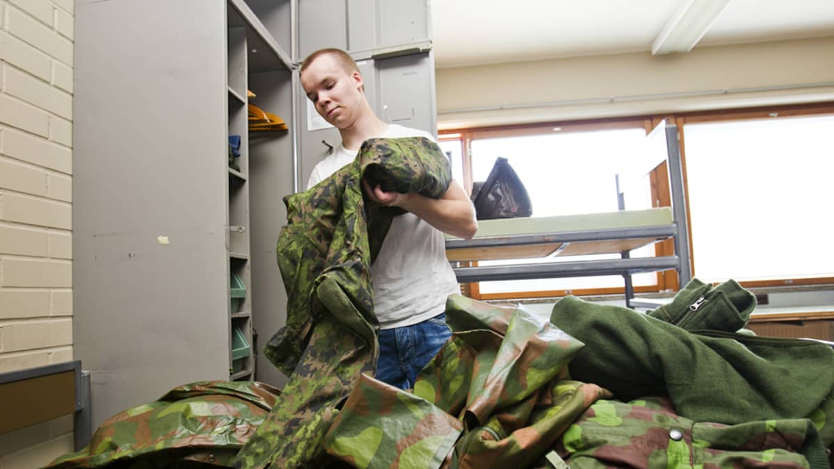 Alokas Juha Kukkonen laittamassa varusteita kaappiinsa.