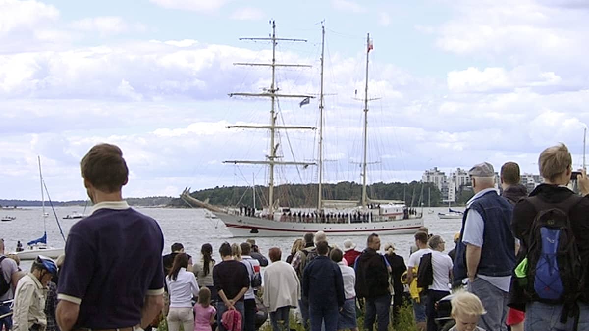 Ihmisiä on kerääntynyt runsaasti Suomenlinnan rantaan katsomaan Helsingistä lähtevien Tall Ships Race -alusten ohipurjehdusta.