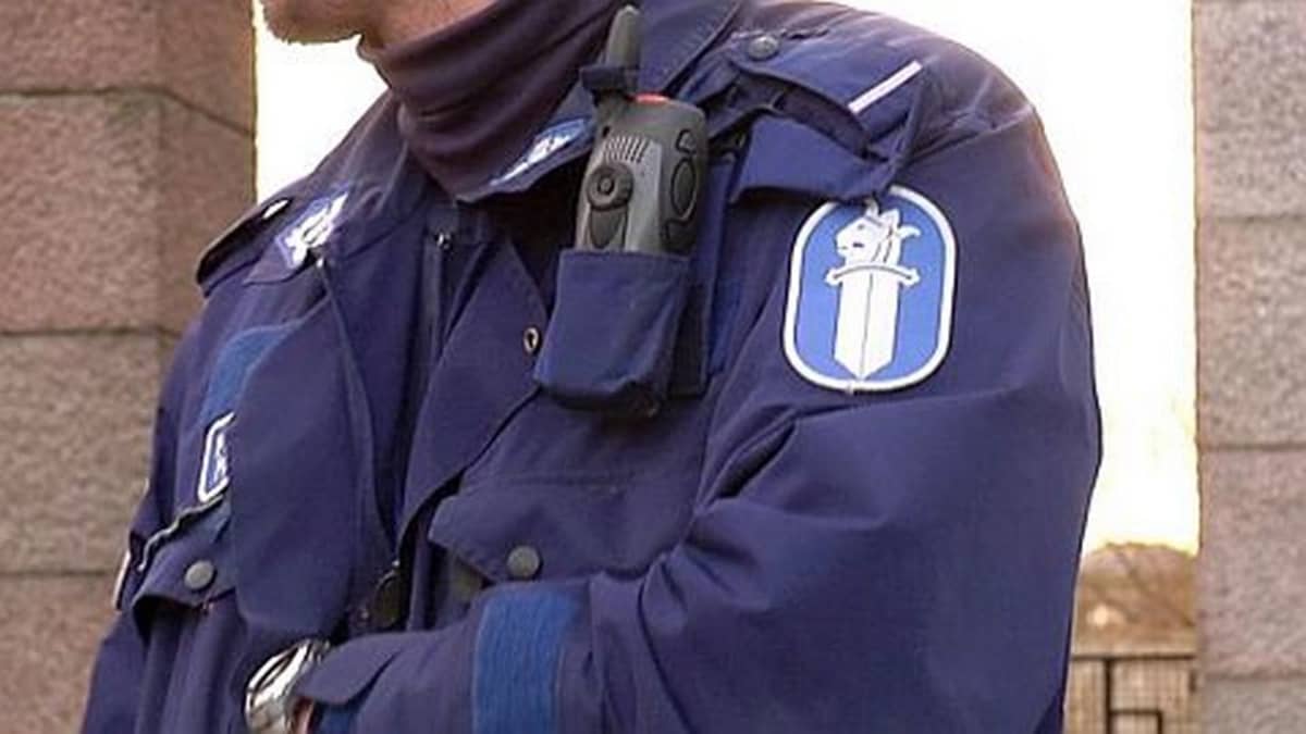 Poliisi käsivarret ristissä.