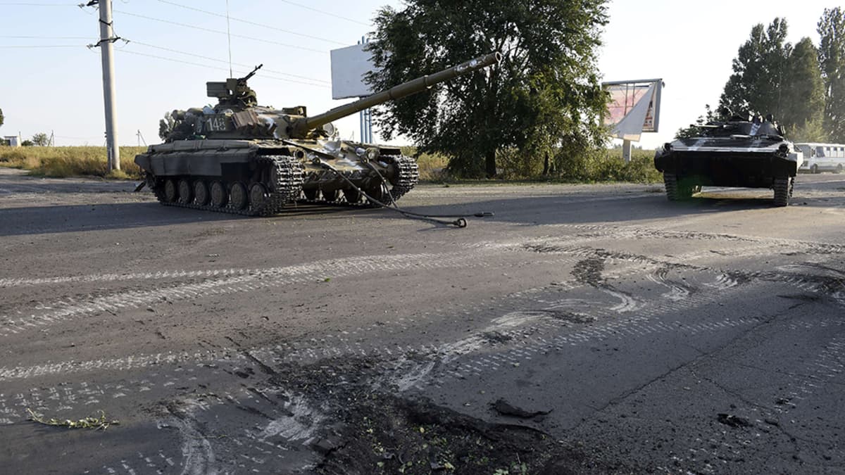 Ukrainalaistankkeja vartiossa yöllisten pommitusten jälkeen Venäjälle johtavan tien varrella Mariupolin lähistöllä 7. syyskuuta 2014. 