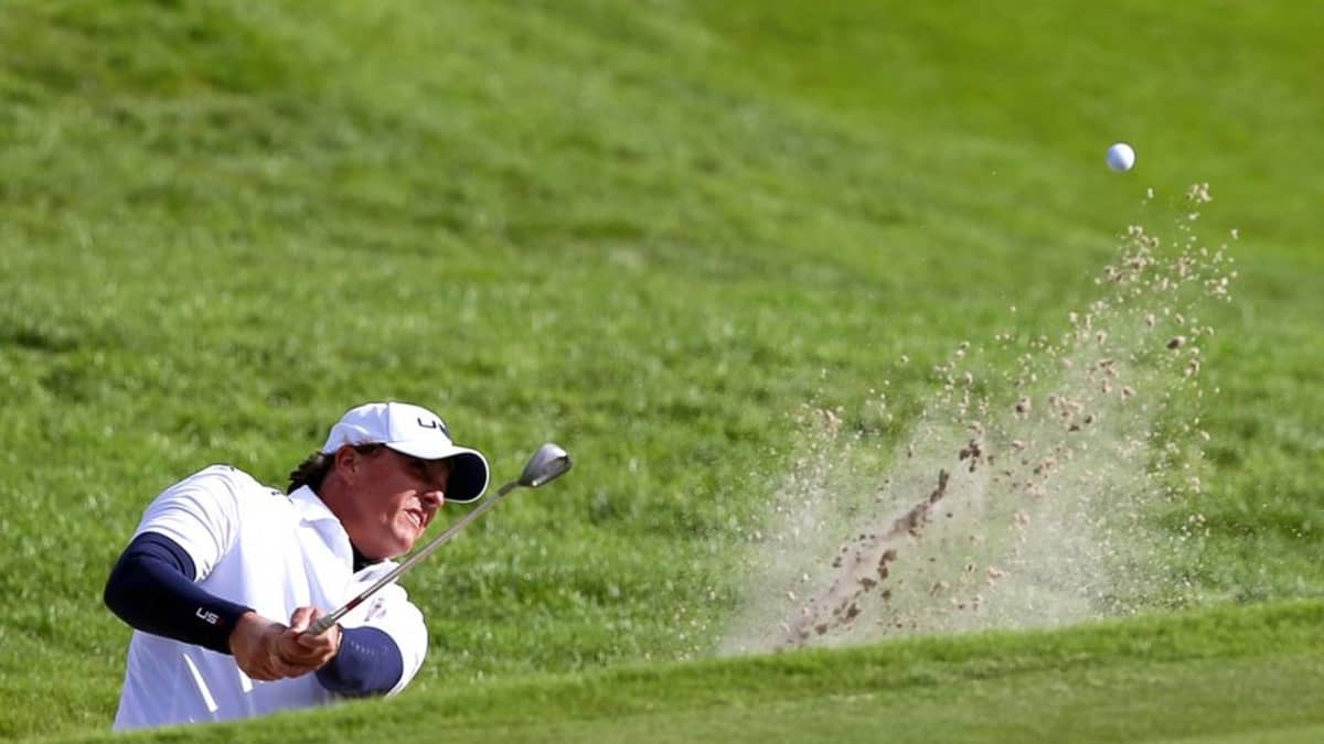 Golfari Phil Mickelson lyö pallon hiekkaesteestä.