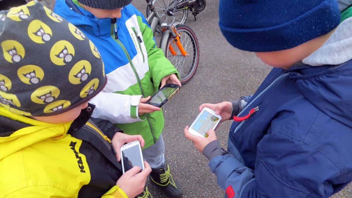 Lapsia pelaamassa älypuhelimilla