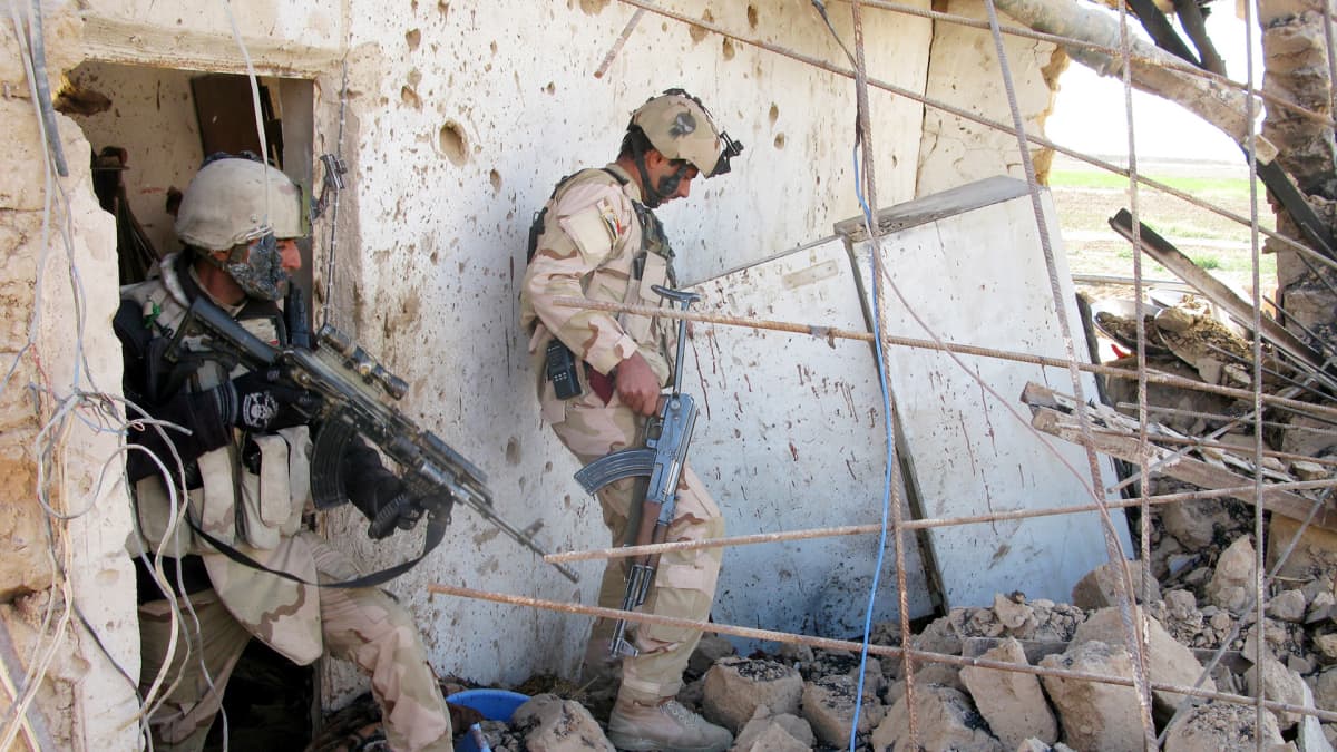 Irakilaissotilaat tarkastavat taistelun jälkiä.