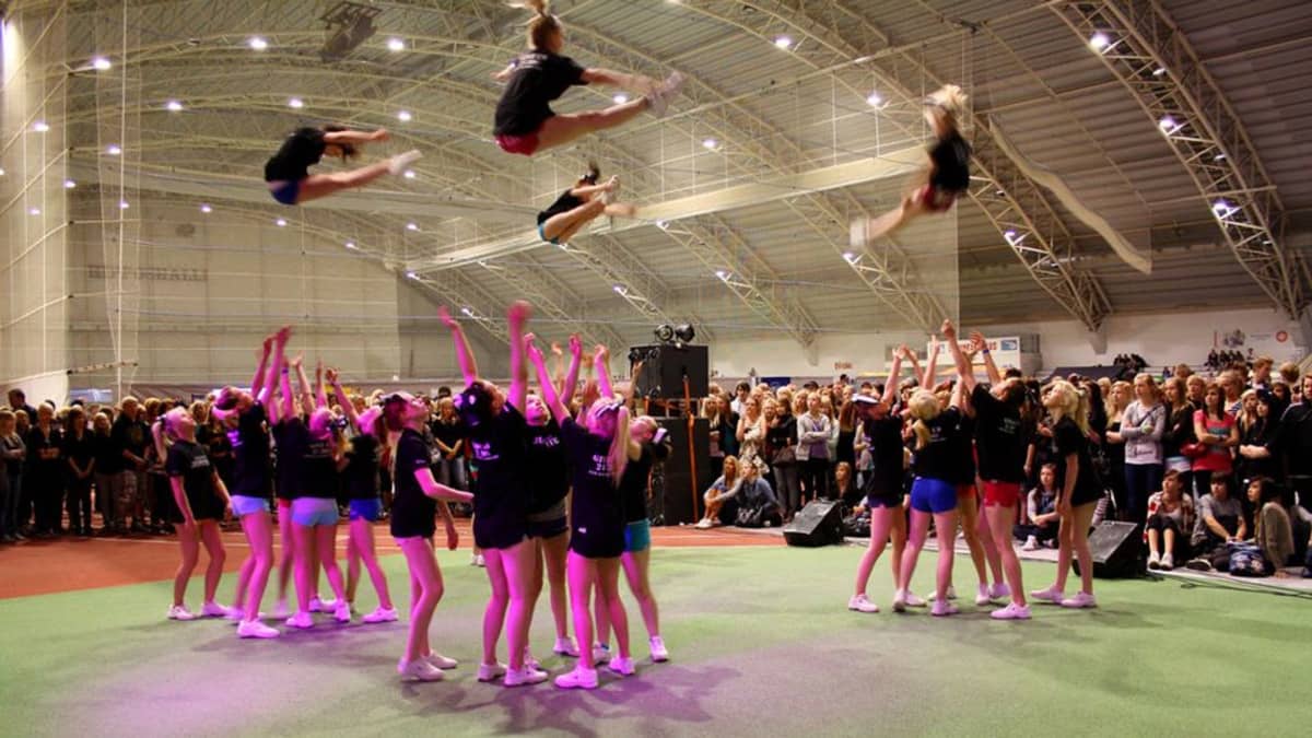 Cheerleading esitys urheiluhallissa.