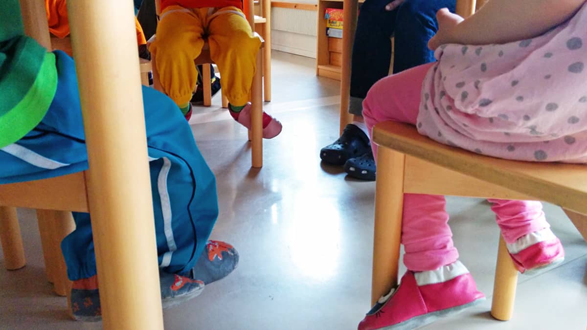 Lasten jalkoja pöydän alla.