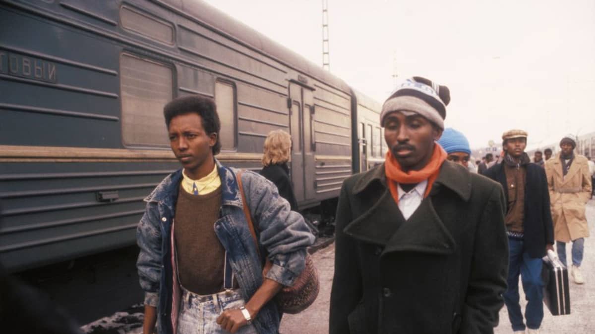 Nuoria somalimiehiä kävelee junan vieressä