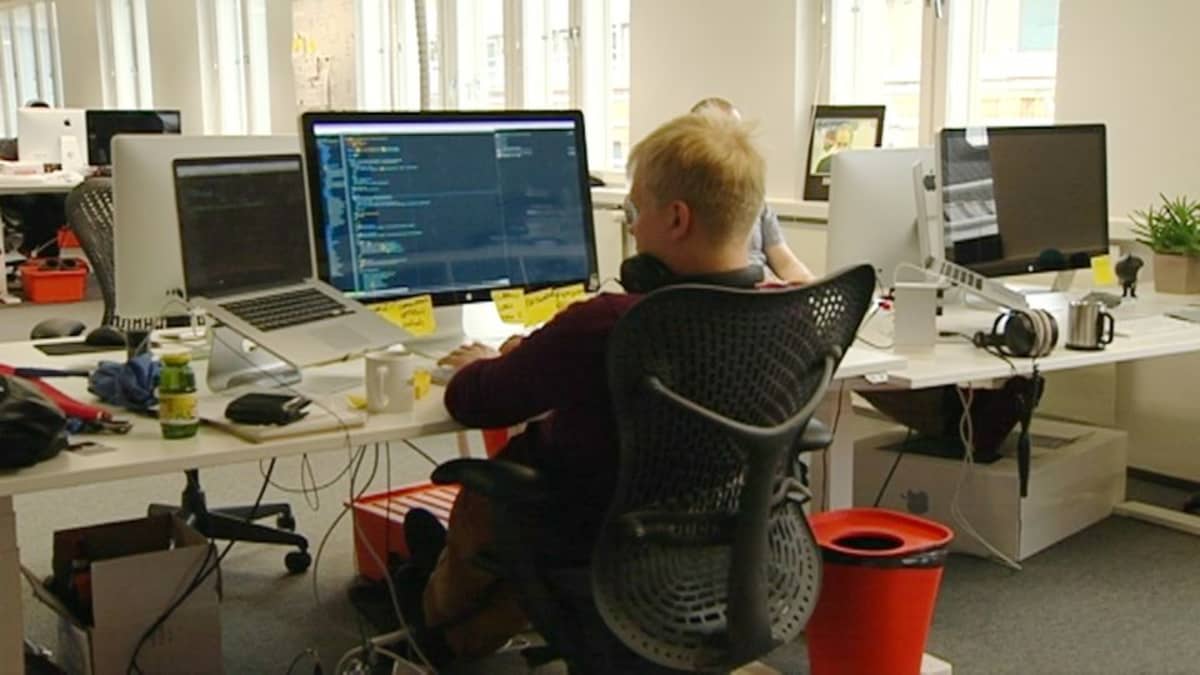 Mies istumassa tietokoneen äärellä toimistossa.