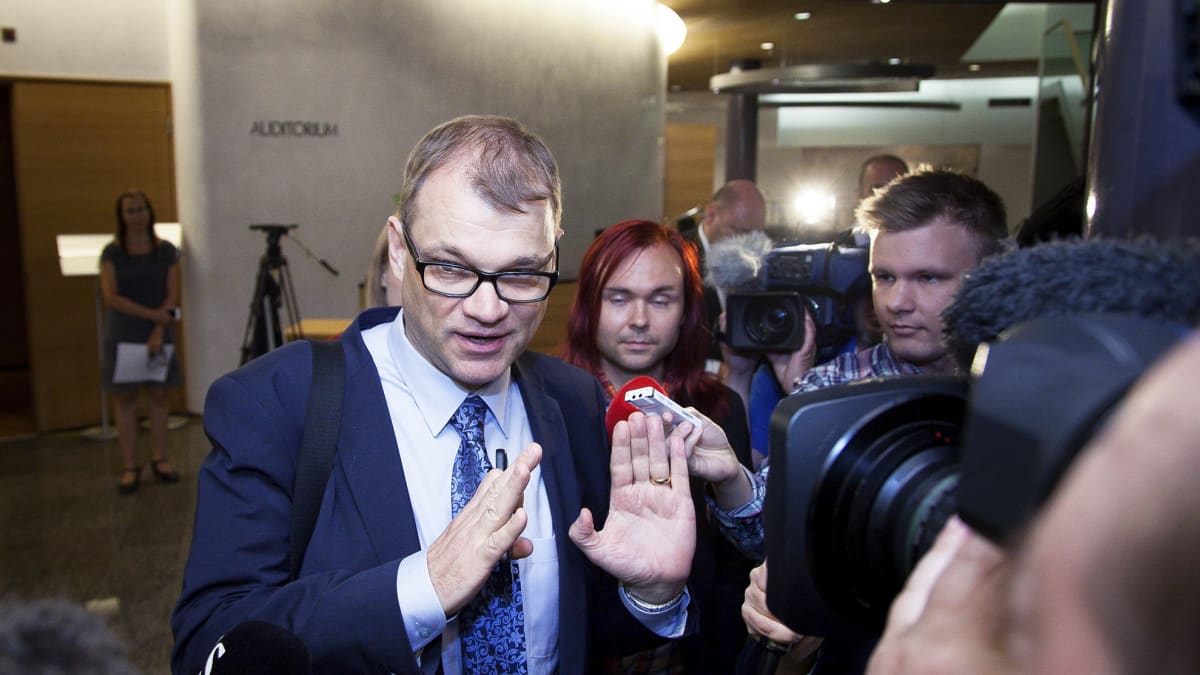 Pääministeri Juha Sipilä puhuu toimittajille saapuessaan suuren valiokunnan kokoukseen eduskunnan Piukuparlamentissä Helsingissä sunnuntaina 12. heinäkuuta.