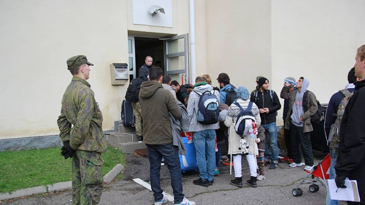 Pihanvalvoja seuraa turvapaikanhakijoiden rekisteröitymistä Tornion järjestelykeskuskessa.