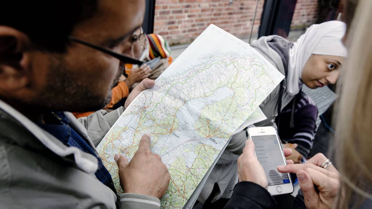 Ruotsiin saapuneet turvapaikanhakijat tutkivat karttaa Malmön rautatieasemalla.