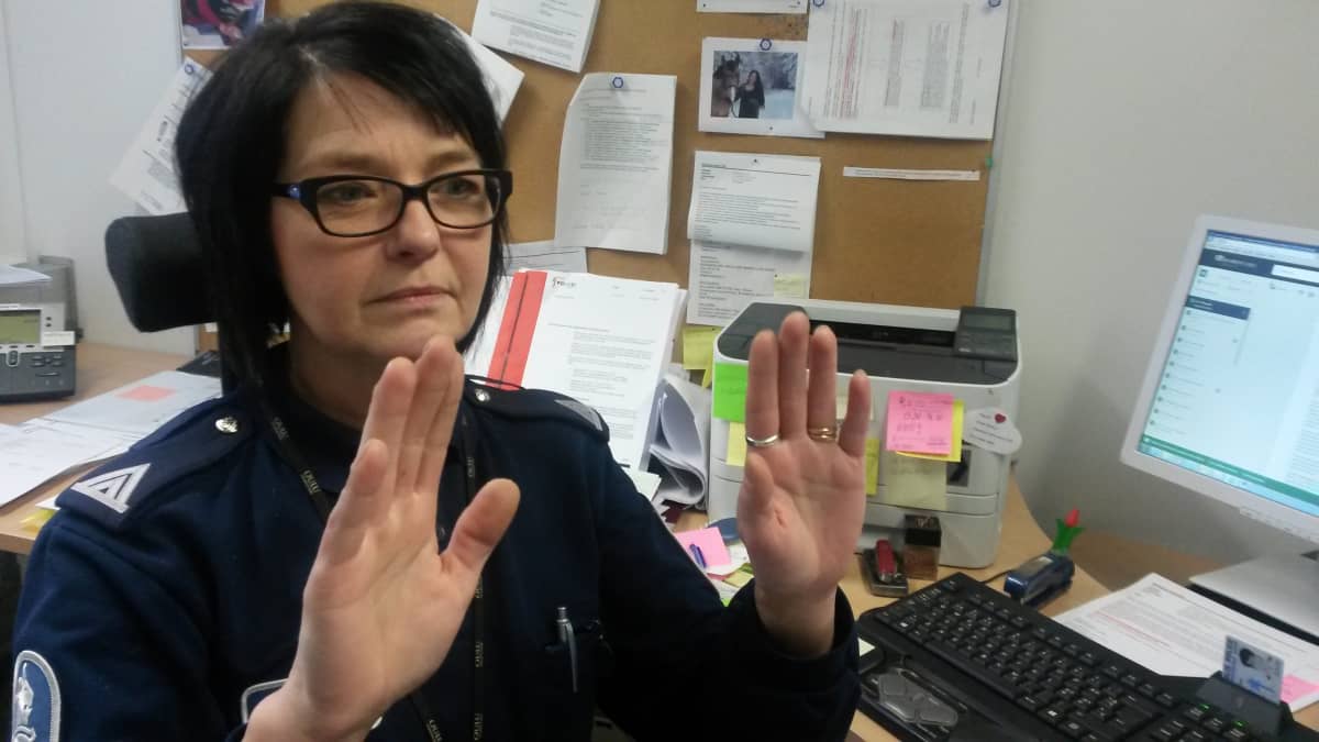 Rikosylikonstaapeli Irmeli Korhonen iestuu työhuoneessaan Oulun poliilaitoksella ja näyttää käsillään ei-sanaa.