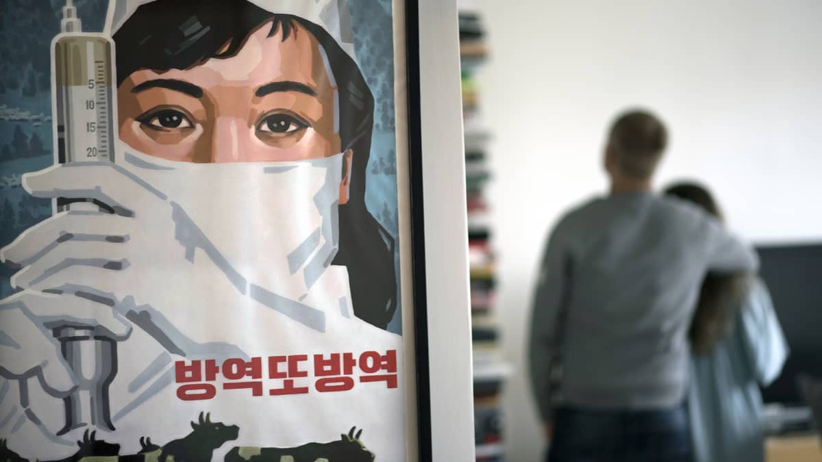 Pohjoiskorealainen propagandajuliste seinällä.