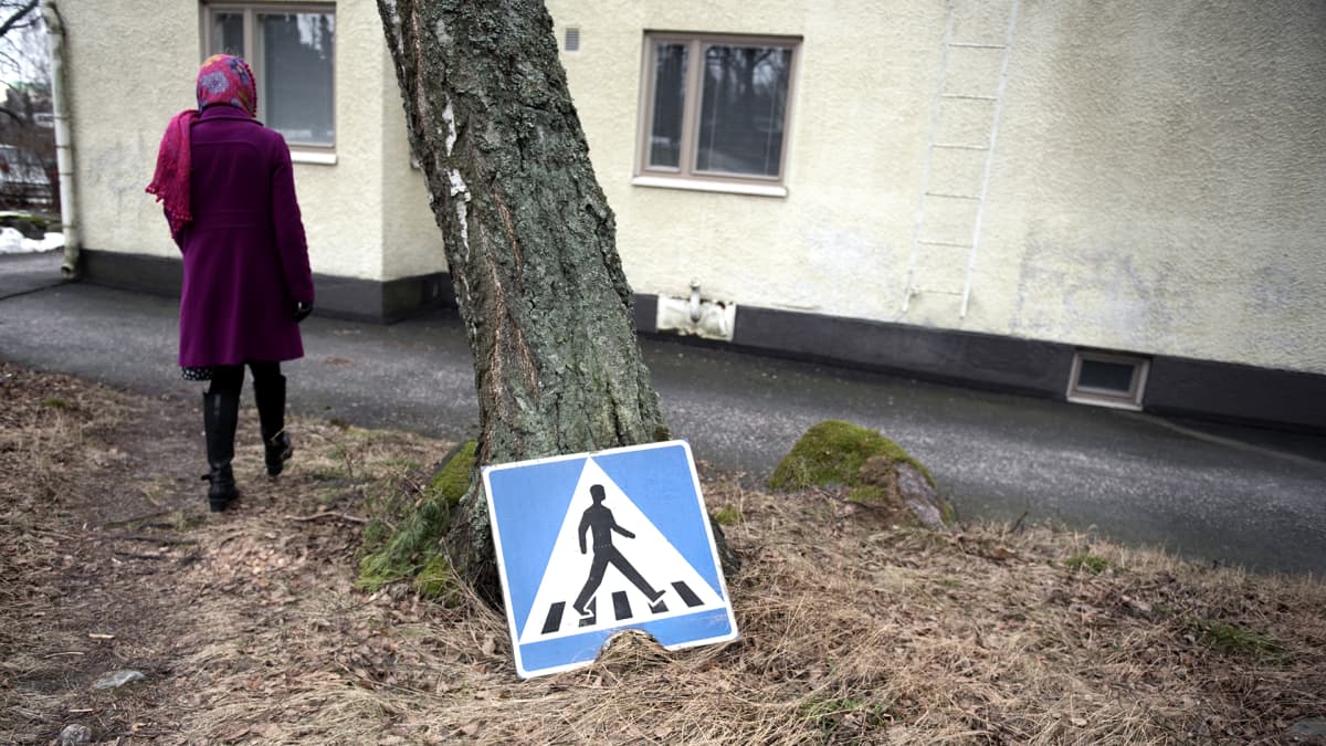 Pirre kävelee maahan irrotetun liikennemerkin vieressä.