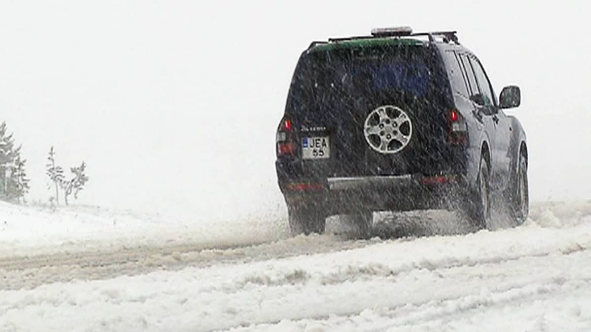 Auto lumisella tiellä Inarissa kesäkuussa.