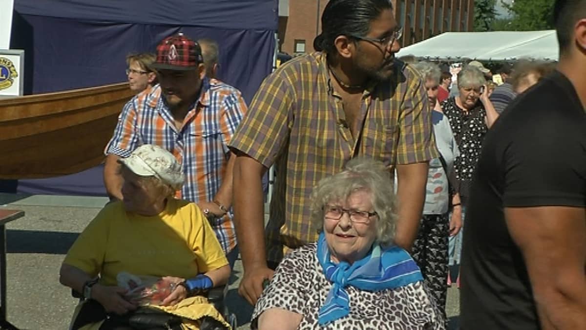 Turvapaikanhakijat ulkoiluttavat vanhuksia Lieksan vanhalla torilla.