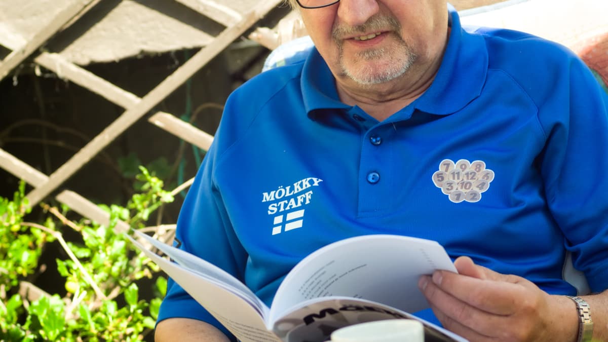 Jouko Pylväs selailee Mölkky-kirjaa.