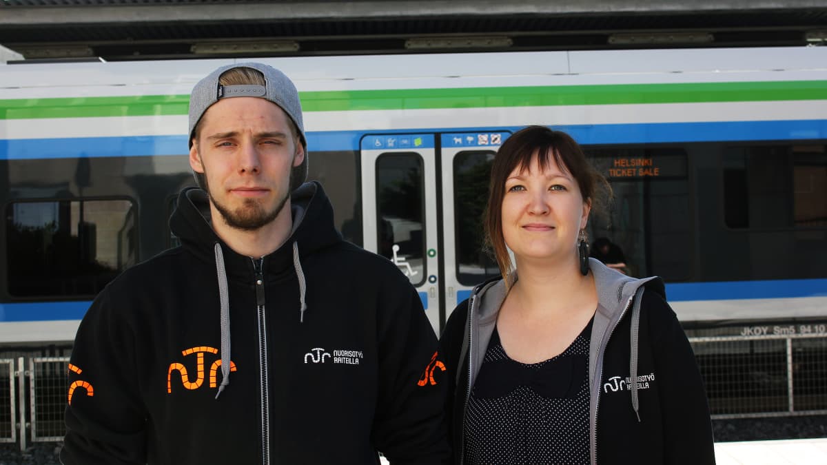 Nuorisotyöntekijät Sauli Taipale ja Niina Koski seisovat juna-asemalla.