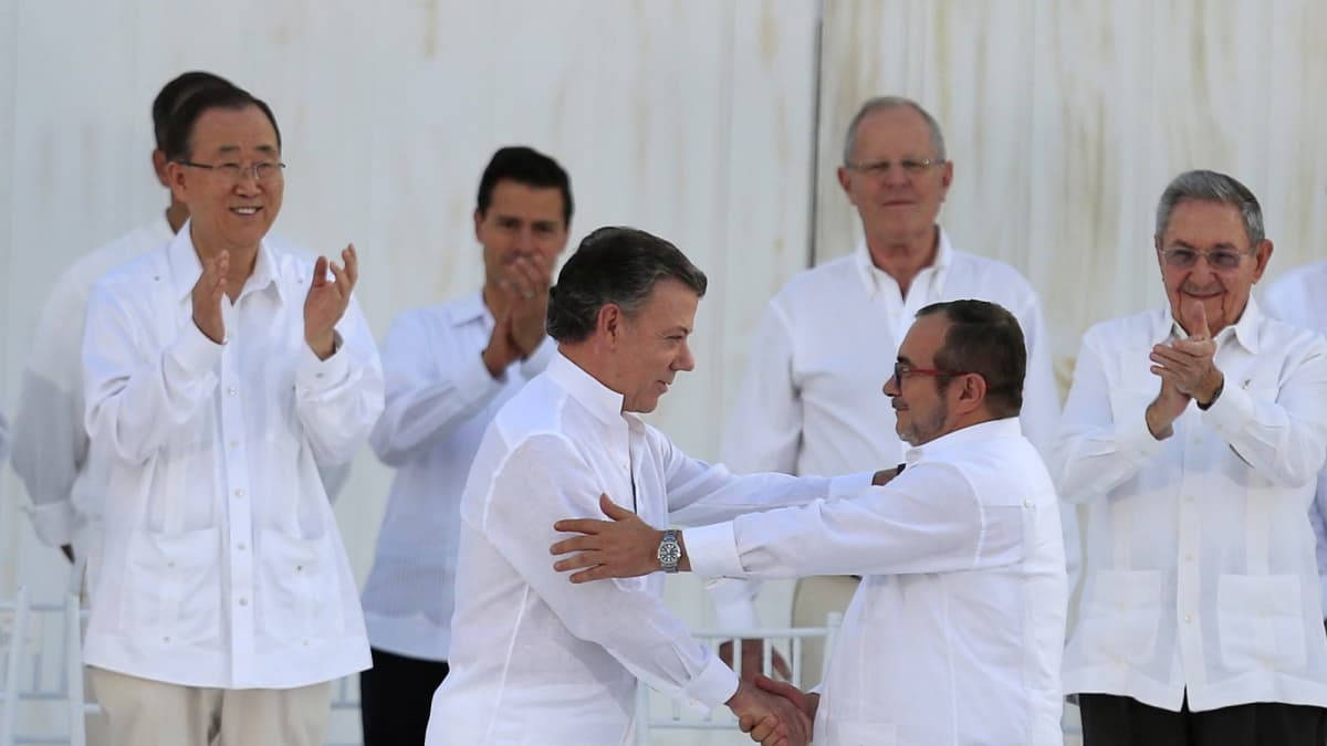 Colombian President Juan Manuel Santos (3-L) and leader of the Revolutionary Armed Forces of Colombia (FARC) Rodrigo Londono Echeverri (R), alias 'Timochenko', shake hands after signing the peace agreement between Colombia's government and FARC to end over 50 years of conflict in Cartagena, Colombia, 26 September 2016. The pact is the result of nearly four years of talks in Havana and was signed at a