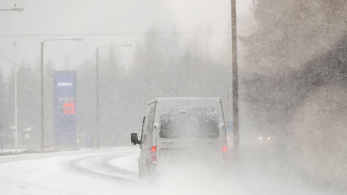 Auto ajaa lumipyryssä.