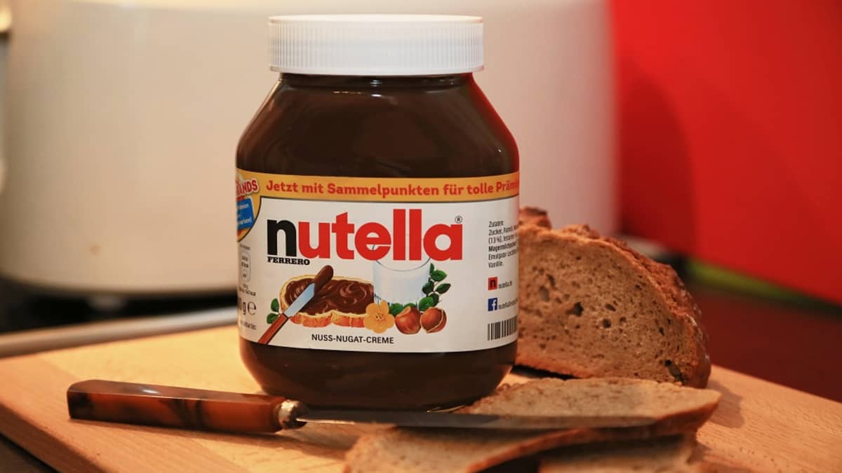 Nutella-purkki ja leivänsiivuja leipälaudalla. 
