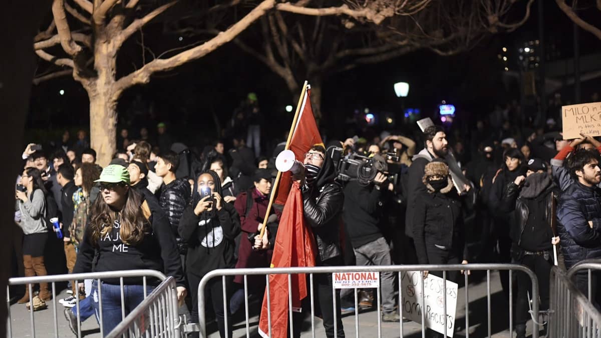 Mielenosoittajia käsissään megafoneja ja lippuja.