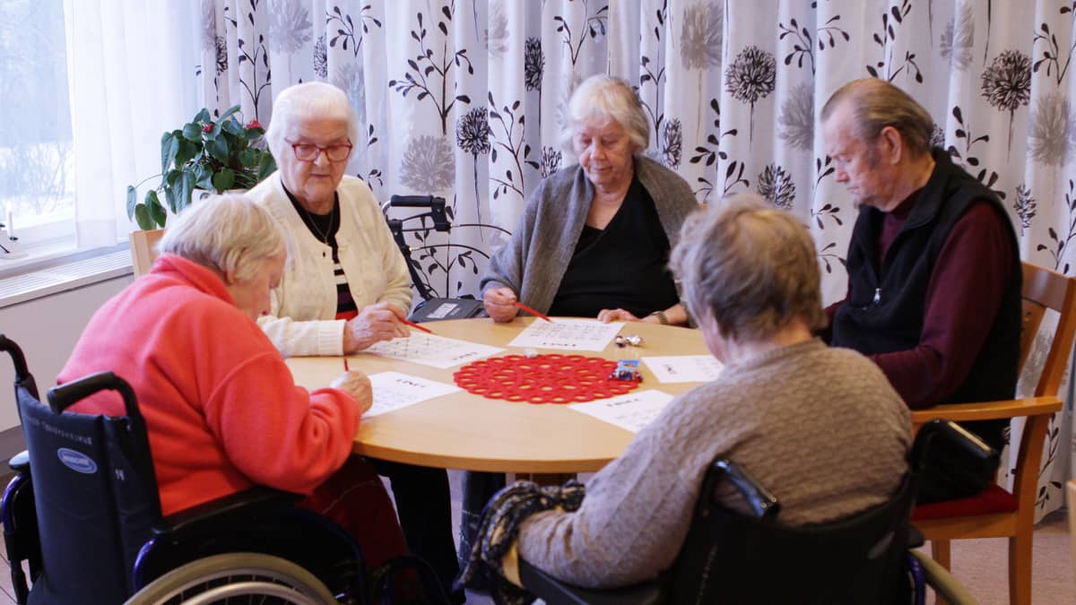 Vanhukset pelaavat bingoa hyvinvointiasemalla.