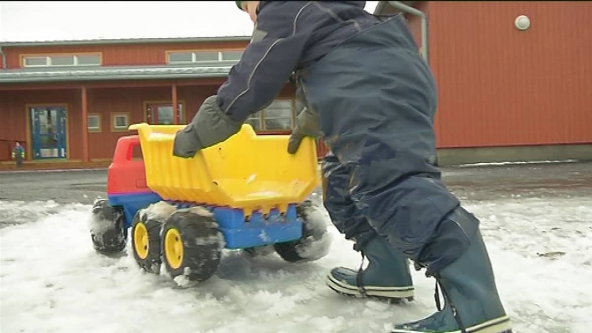 lapsi työntää leluautoa ulkona