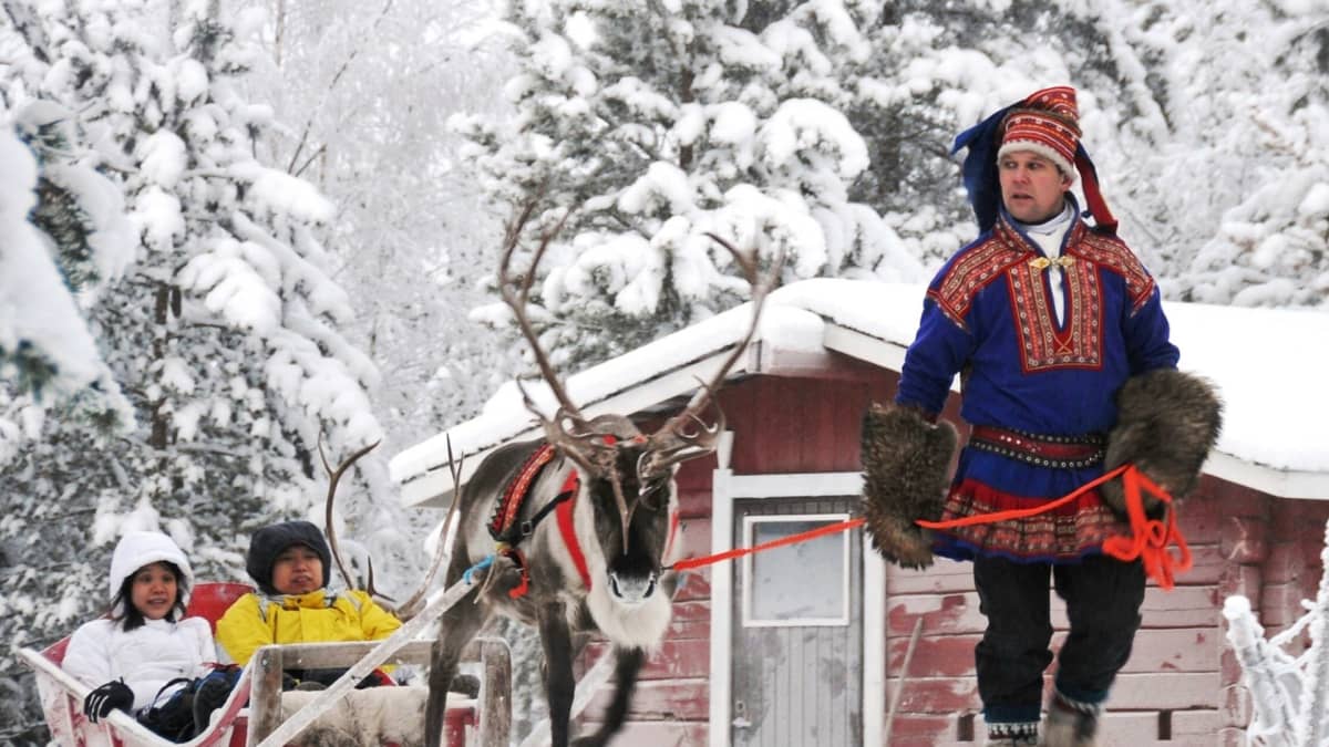 Kiinalaisturisteja poroajelulla Rovaniemellä.