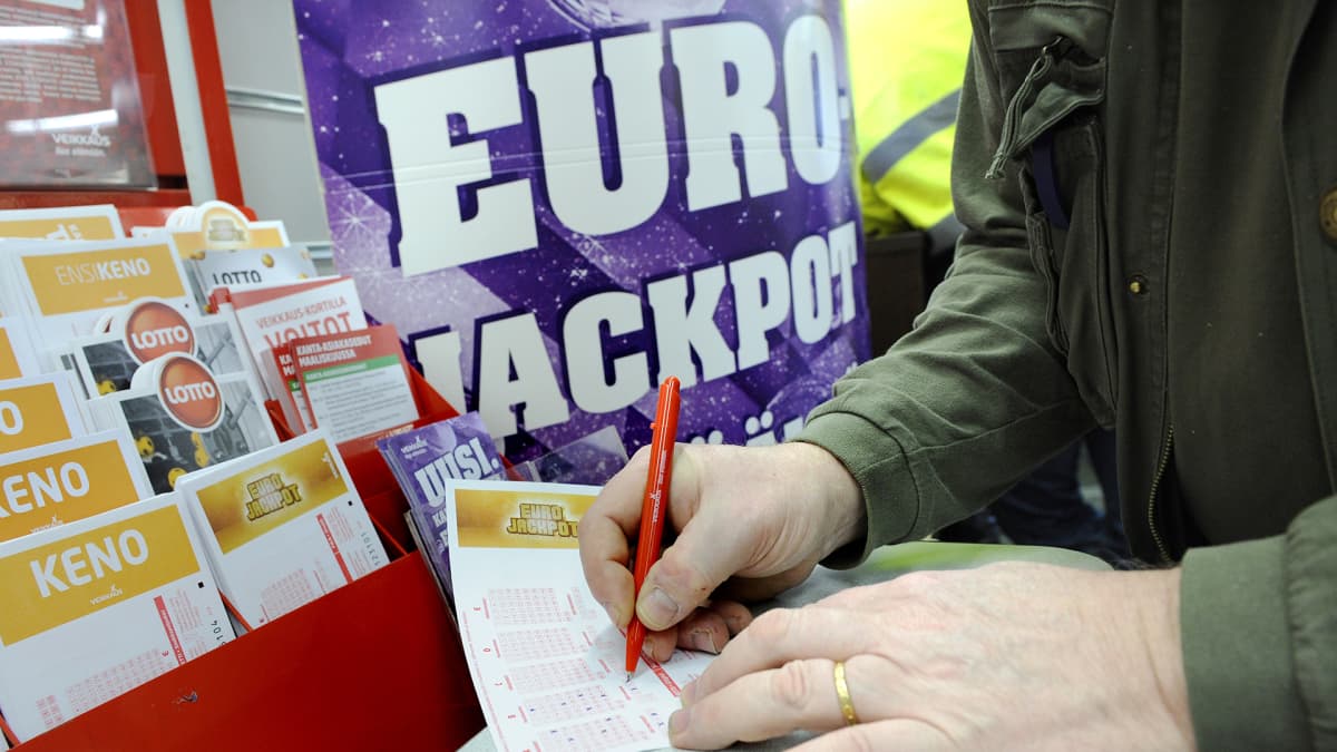 Mies täyttää Eurojackpot-kuponkia.