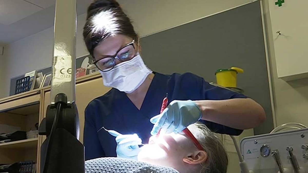 Suuhygienisti Jaana Ainali tarkastaa potilaan hampaat Ylikiimingin koululla.