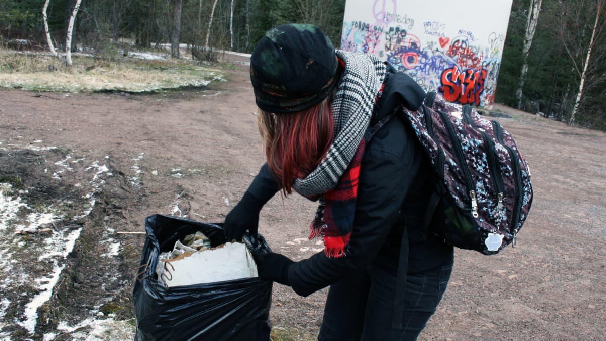 Tyttö kerää roskia.