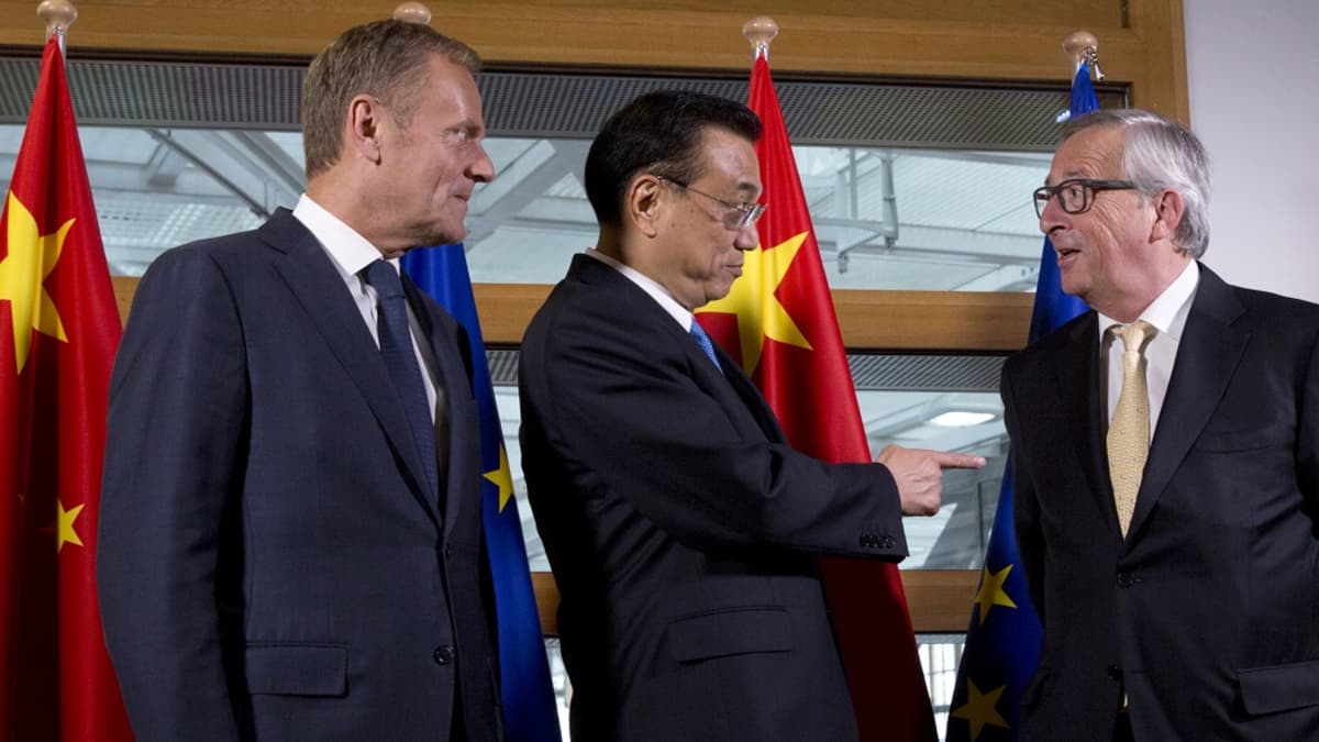 Donald Tusk, Li Keqiang ja Jean-Claude Juncker puhuvat. Taustalla näkyvät Kiinan ja EU:n liput.
