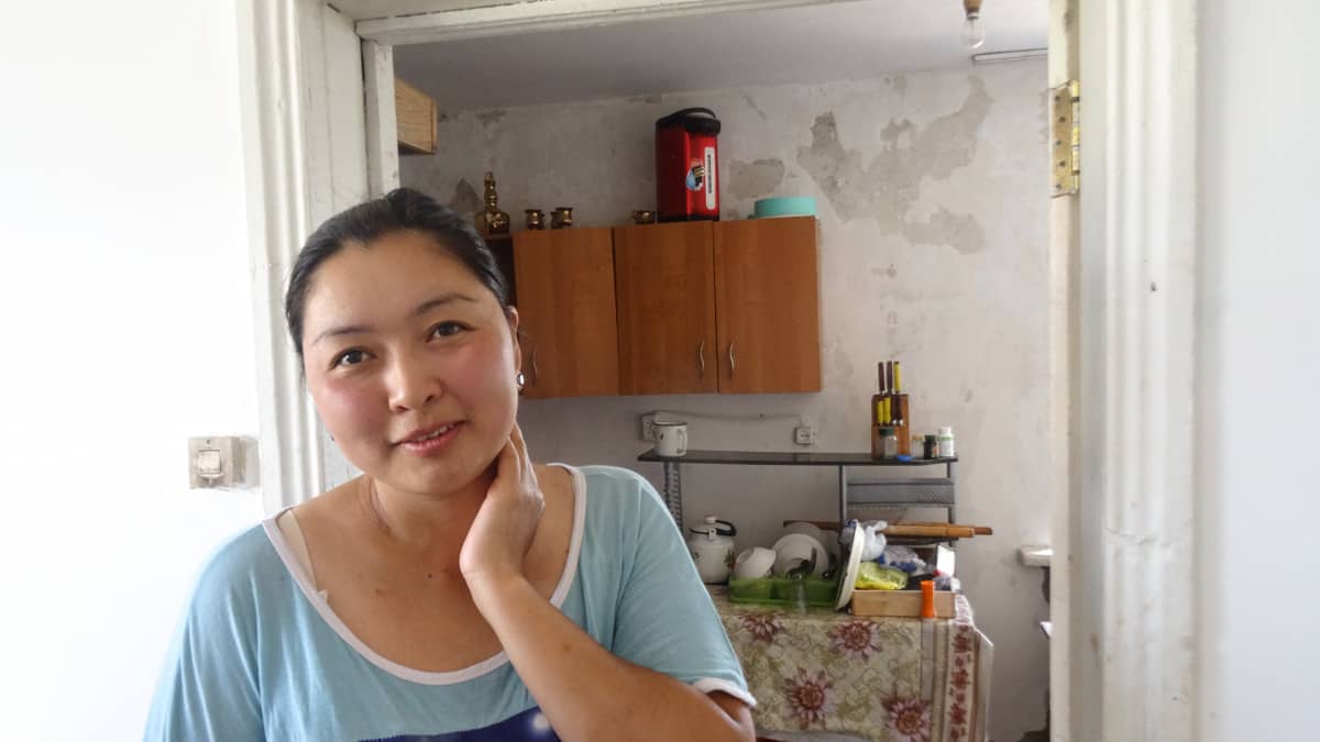Damira Aitymbetova korjaa perheen talon tulvavahinkoja.